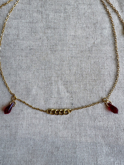 Goldene Gesichtskette mit roten Tropfenanhängern